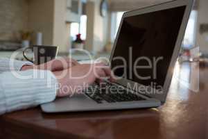 Woman using laptop in kitchen