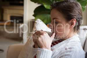 Woman drinking coffee in living room