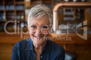 Smiling senior woman looking at camera in restaurant