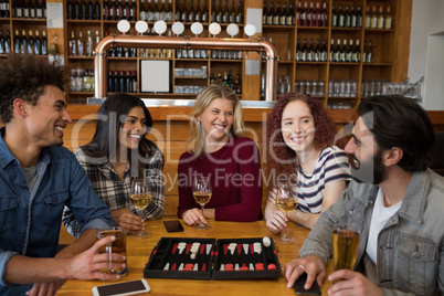 Friends interacting while having glass of beer Friends interacting while having glass of beer