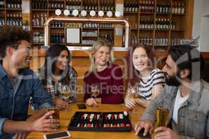 Friends interacting while having glass of beer