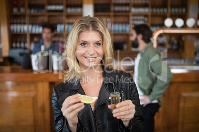 Beautiful woman having tequila shot in bar