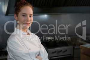 Smiling female chef with hands crossed in the kitchen