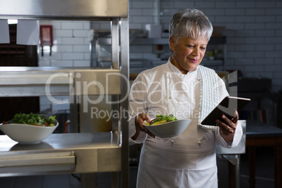 Female chef holding digital tablet