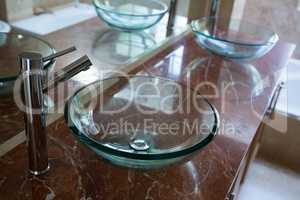 Glass sinks with steel taps installed on marble platform
