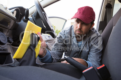 Auto service staff cleaning car interior