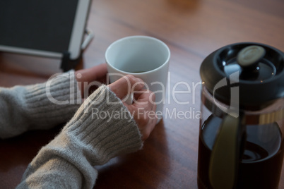Woman having cup of coffee at home