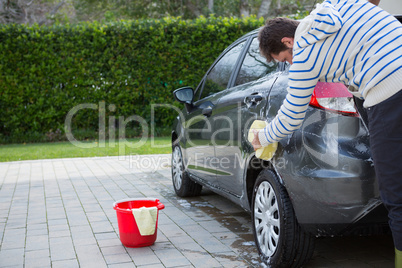 Auto service staff washing a car with sponge