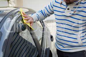 Auto service staff cleaning a car with duster