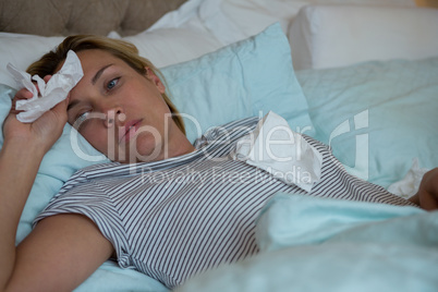 Sick woman lying on bed