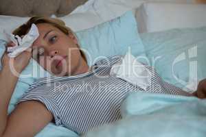 Sick woman lying on bed