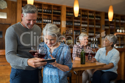 Senior couple looking their photos on mobile phone
