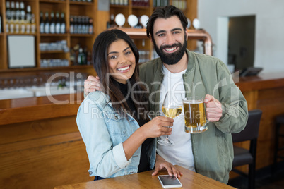 Smiling couple having drinks in bar