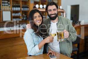 Smiling couple having drinks in bar