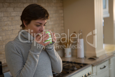 Woman drinking coffee in kitchen