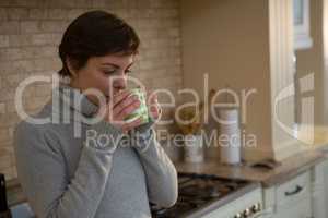 Woman drinking coffee in kitchen