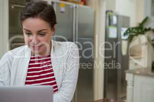 Woman using laptop in kitchen