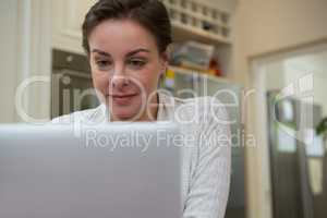 Woman using laptop in kitchen