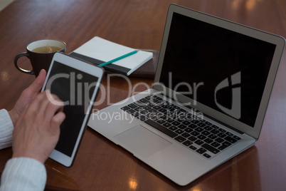 Woman using digital tablet at table