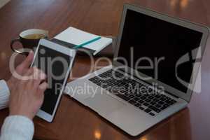 Woman using digital tablet at table