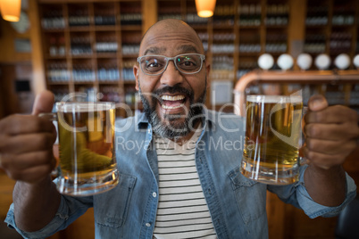 Smiling man having glasses of beer in restaurant