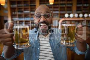 Smiling man having glasses of beer in restaurant