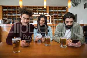 Friends using mobile phone on table