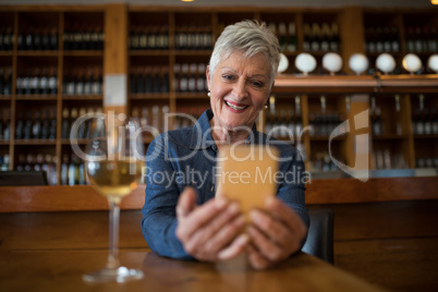 Senior woman using mobile phone in restaurant