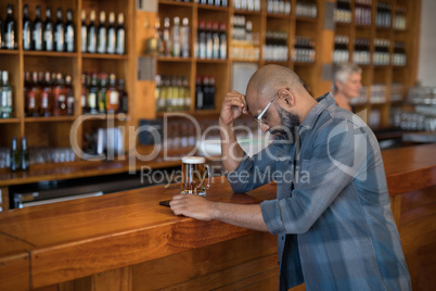 Depressed man standing at counter