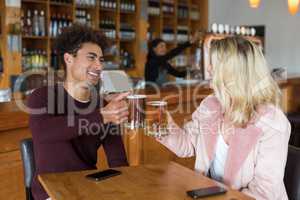 Couple toasting glass of beer in bar