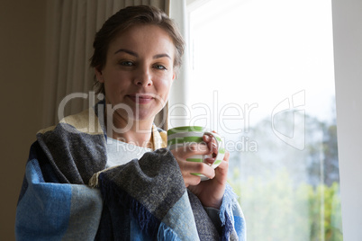 Smiling woman having cup of coffee at home