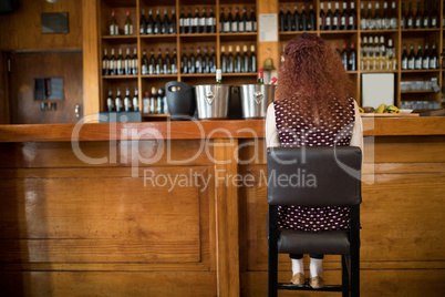 Woman sitting on chair at counter