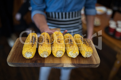 Waiter holding tray of baby corn in bar