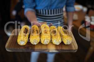 Waiter holding tray of baby corn in bar