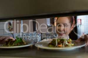 Female chef reading order in the kitchen