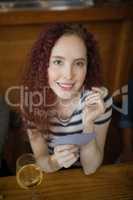 Beautiful woman holding cards in bar