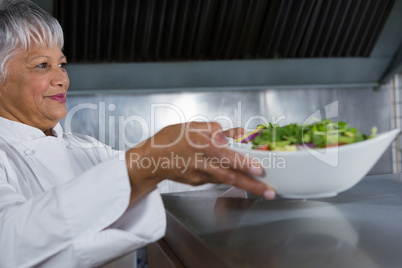 Female chef holding food plate