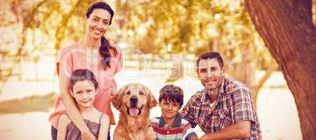 Portrait of happy family with dog in park