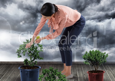 Businesswoman caring for plants gardening in city clouds
