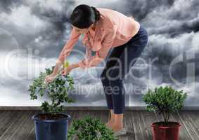 Businesswoman caring for plants gardening in city clouds