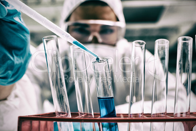 Close-up of science student dropping blue liquid in test tube