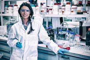 Portrait of a smiling chemist leaning against desk