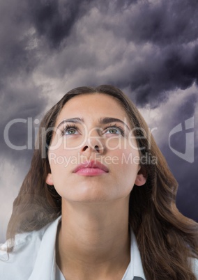 Woman looking up with dark cloudy background
