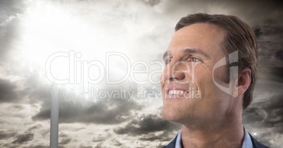 Man looking up with stadium lights and clouds background