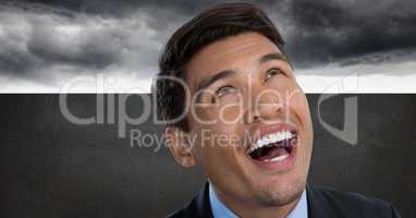 Man looking up and laughing with grey background