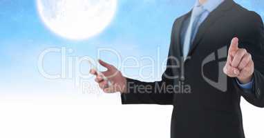 Businessman touching air and holding phone in front of moon