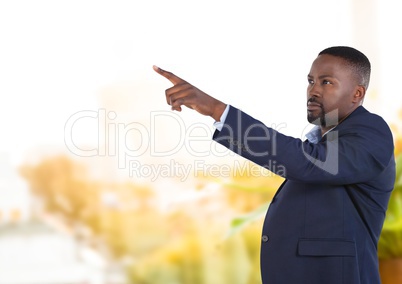 Businessman pointing touching air in front of greenery