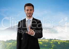 Businessman touching air in front of green hills