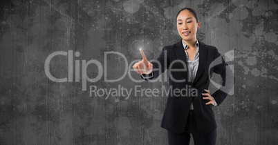 Businesswoman touching air in front of grey wall