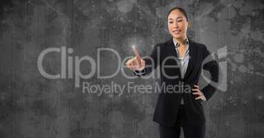 Businesswoman touching air in front of grey wall